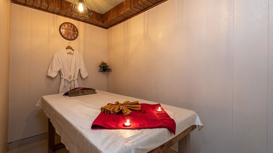 View of the massaging table with a bathrobe hung near the pillow at DLS Highland Resort and Spa, Mussoorie.